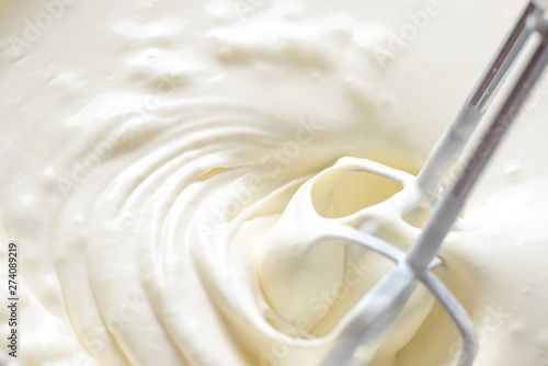 Whipping cream with a mixer. Bubbles on cream