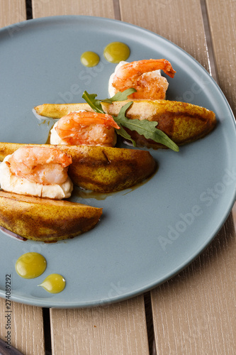 Grilled tiger shrimps with honey rear and cream cheese. Grilled seafood. On wooden background.