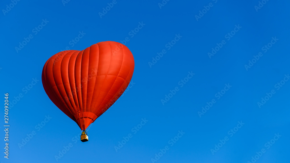 Obraz premium balloon heart on blue sky background symbol of love and romance