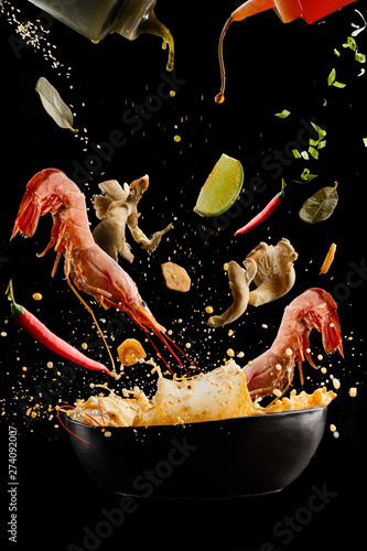 Obraz na płótnie flying soup tom yam with shrimp and spices. Concept of food preparation in low gravity mode, food levitation. Separated on black background. High resolution image w salonie