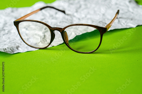 White crumpled paper and green paper. eyeglass concept.