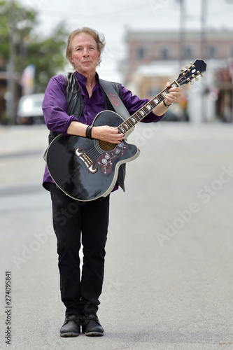 Street musician with guitar and big personality photo