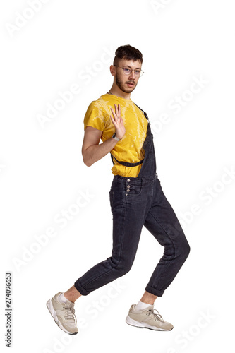 Full-length portrait of a funny guy dancing in studio isolated on white background. © nazarovsergey