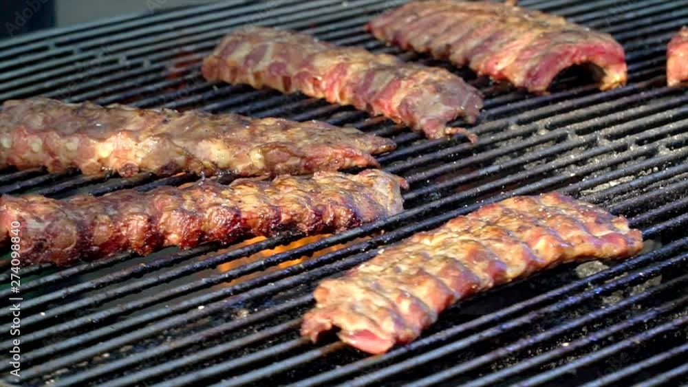 Grilled pork ribs on the grill. The meat spins on the grill. Barbecue - preparing beef ribs on charcoal grill. Grilled pork. Grilled pork ribs on the grill. The meat spins on the grill. Barbecue - preparing beef ribs on charcoal grill. Grilled pork.