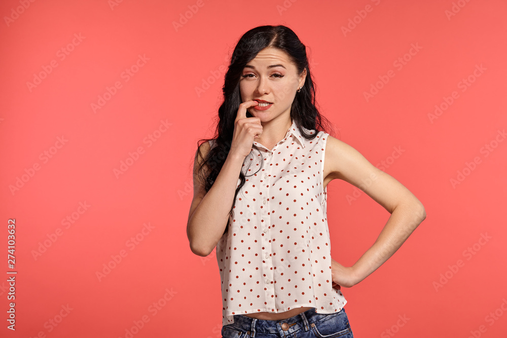 Studio shot of a beautiful girl teenager posing over a pink background. Studio shot of a beautiful girl teenager posing over a pink background.