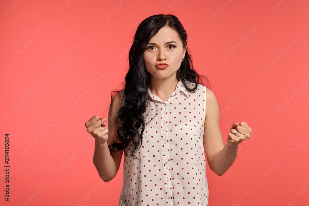 Studio shot of a beautiful girl teenager posing over a pink background. Studio shot of a beautiful girl teenager posing over a pink background.