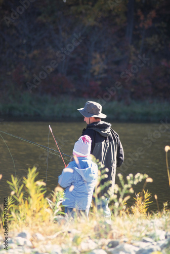 A Father and Daughter Fishing in a Lake on a Fall Day