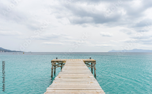 Fototapeta Naklejka Na Ścianę i Meble -  Wooden pier, calm turquoise waters in the Mediterranean Sea, holiday scenes with a sense of calm