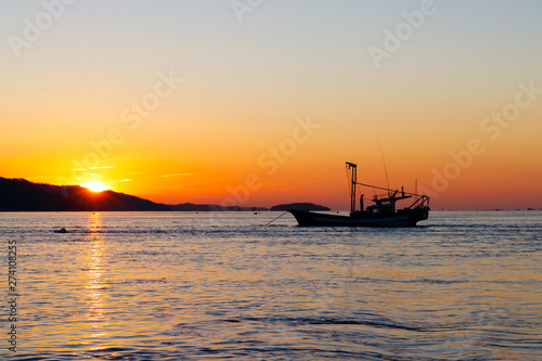 Anchored sea fishing boat.  sunset and fishing boat. © MYUNGKU