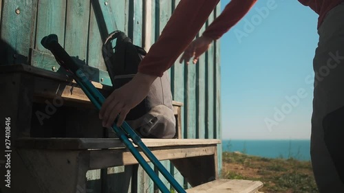 Man hiking on summer vacation or holiday, natural outdoor lifestyle. Backpacker walking with trekking poles, having rest during summer hike. photo