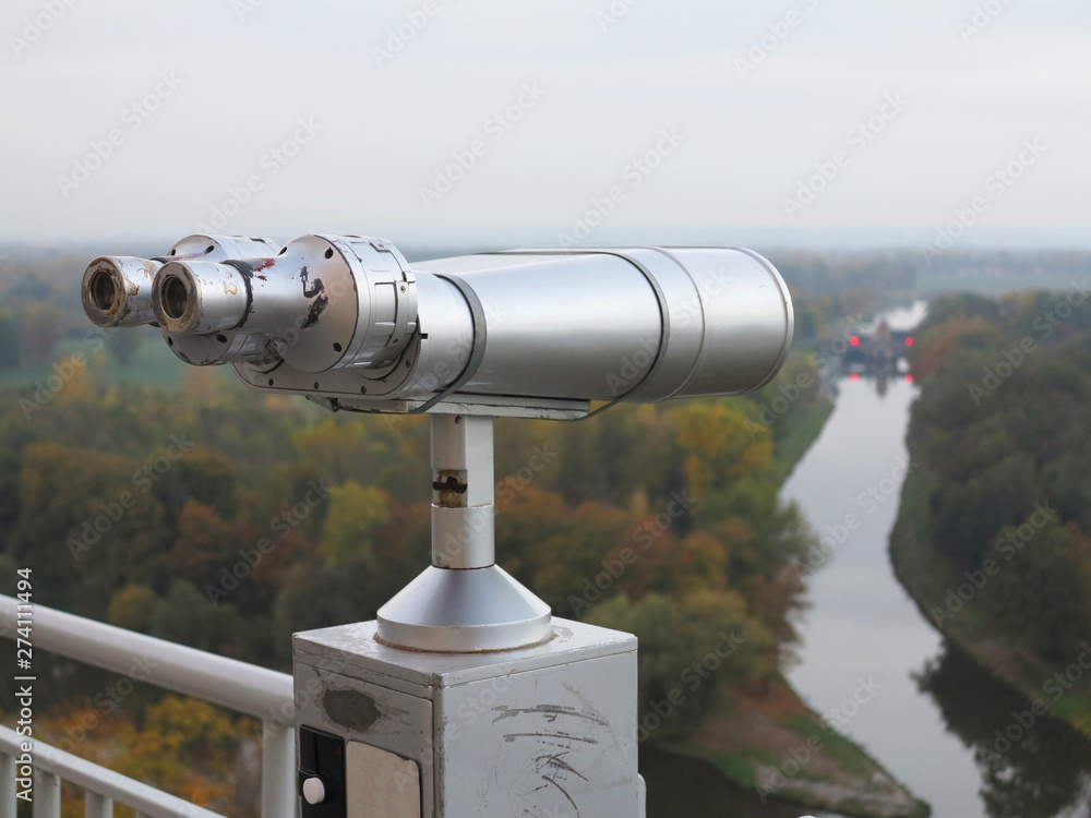 the long metal binocular with river landscape