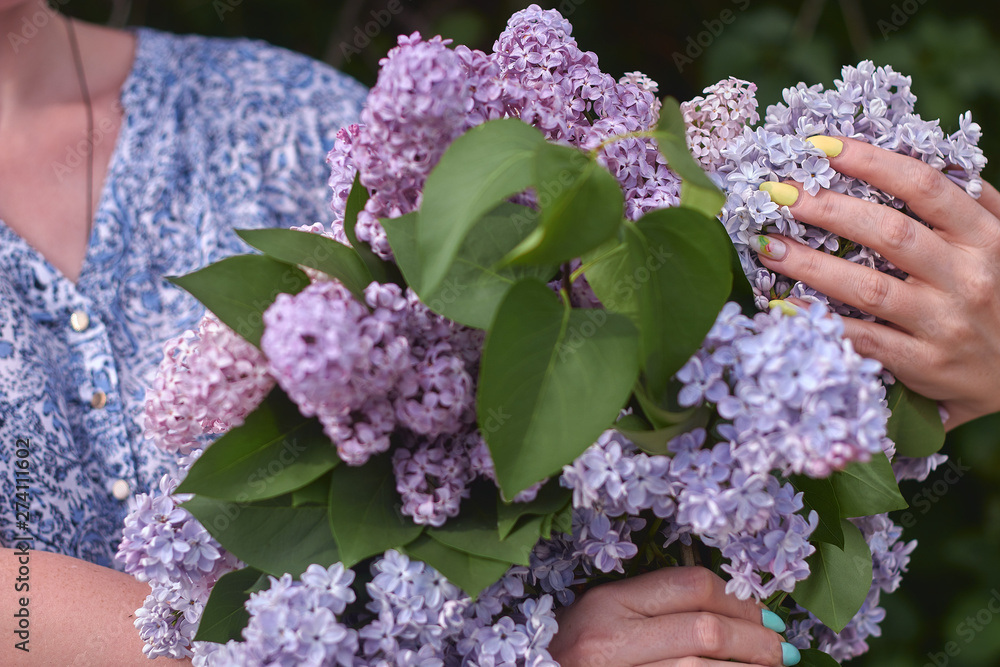 young girl in blue jeans holding a large bouquet of lilacs young girl in blue jeans holding a large bouquet of lilacs