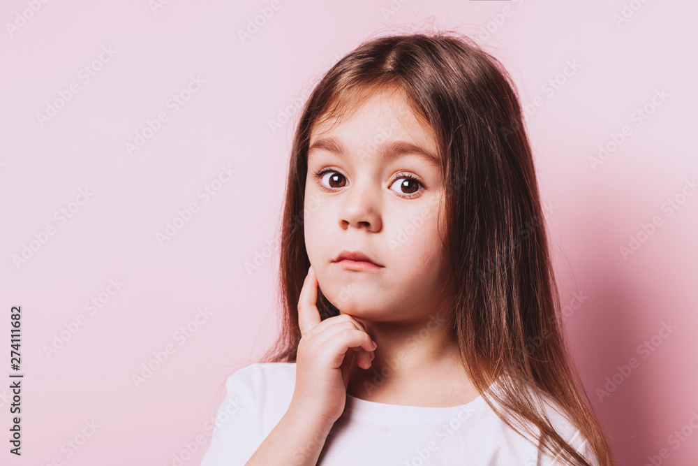 Funny portrait of little doubt girl on pink background. Funny portrait of little doubt girl on pink background.