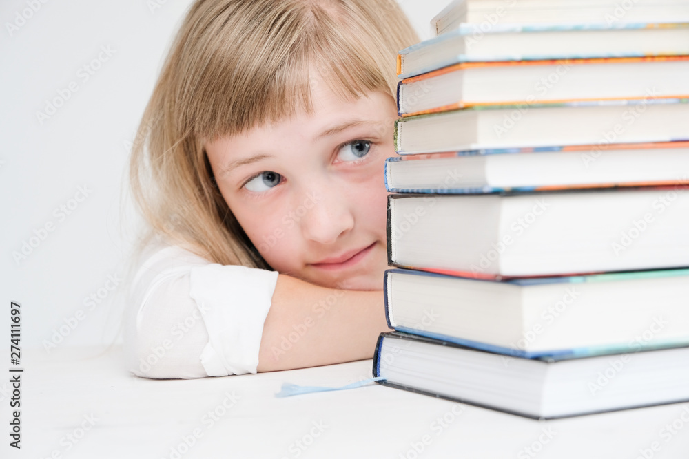 Beautiful little girl hiding behind a stack of books Beautiful little girl hiding behind a stack of books