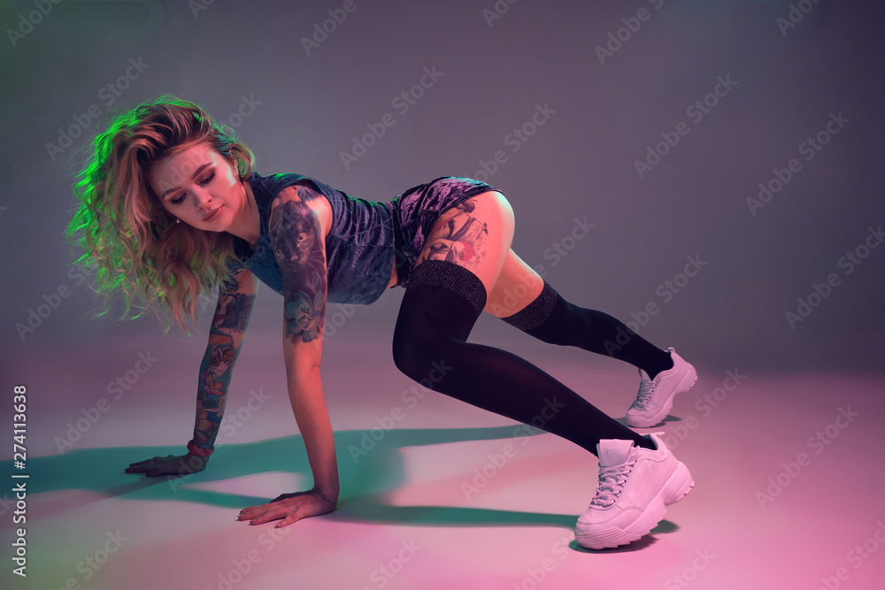beautiful caucasian blonde girl in velour blue booty shorts and black  stockings dancing twerk on pink background Stock Photo | Adobe Stock