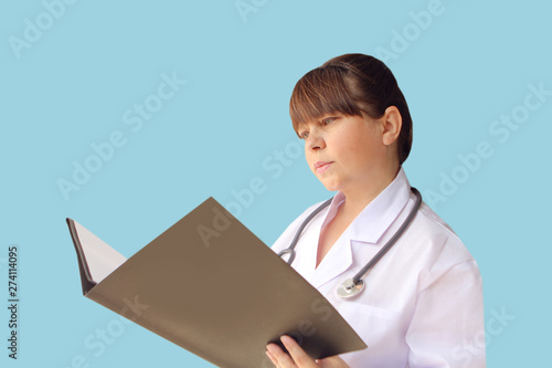 woman doctor in white coat with phonendoscope on her neck holding a folder with documents on an isolated blue background, concept