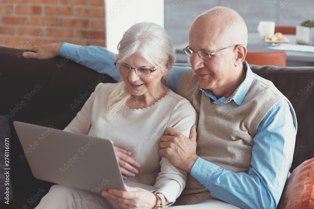 Senior couple browsing the internet together - obrazy, fototapety, plakaty 