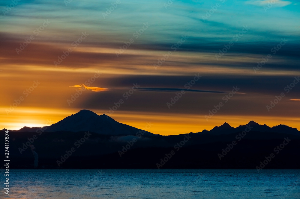 Dramatic Sunrise Over Mt. Baker and Bellingham Bay.  First light behind Mt. Baker, Washington, can be a dramatic and colorful event in the Pacific Northwest.
