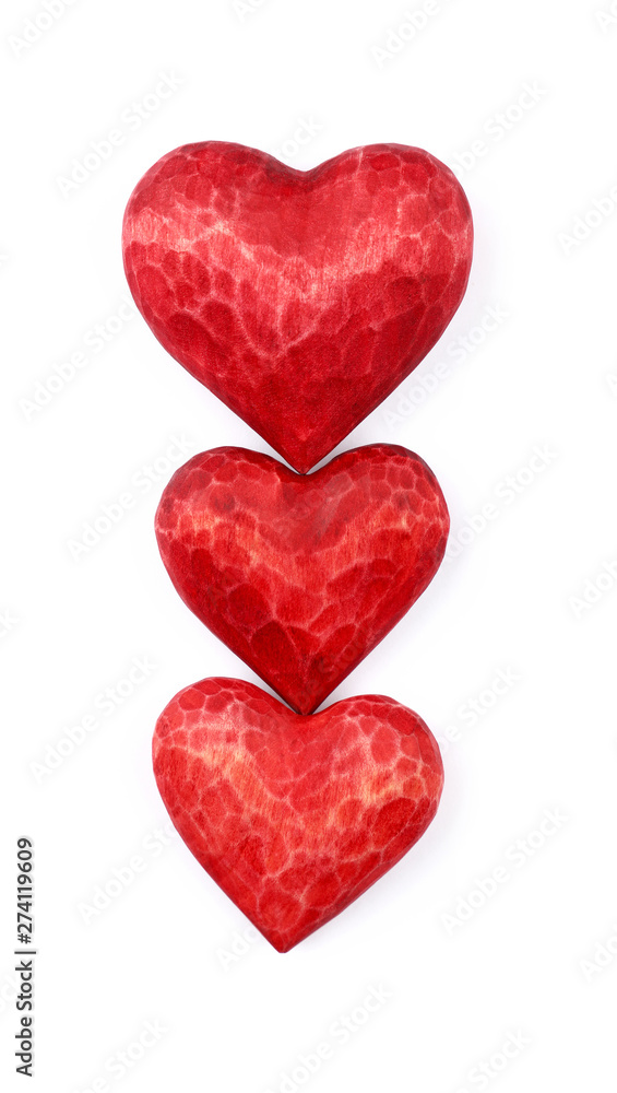 Three red wooden carved hearts isolated on white