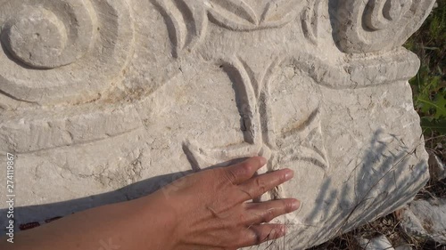 Antalya region, Turkey - 8th of July 2018: 4K Sagalassos ancient city tour - Hand touching a chrisscross engraved on the antient column basement photo