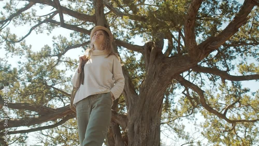 Attractive young woman enjoying her time outside in park with sunset in background.
