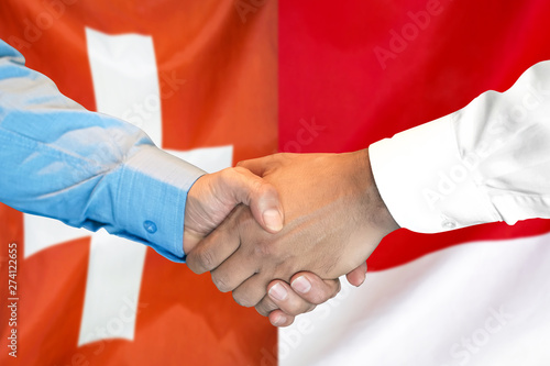 Business handshake on the background of two flags. Men handshake on the background of the Switzerland and Monaco flag. Support concept