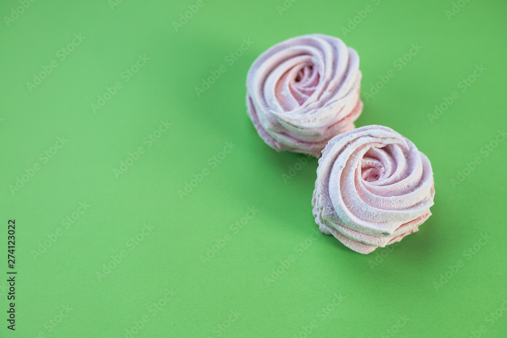 Closeup Freshly baked dessert meringues marshmallow zephyr cake isolated on green background. candy dessert. Closeup Freshly baked dessert meringues marshmallow zephyr cake isolated on green background. candy dessert.