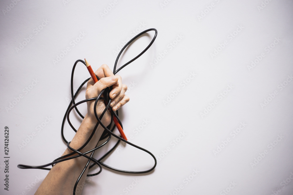 Close-up of hand holding a red pen with a black wire around them on a white background with copy space – Cable warped over person’s arm and writing tool Close-up of hand holding a red pen with a black wire around them on a white background with copy space – Cable warped over person’s arm and writing tool