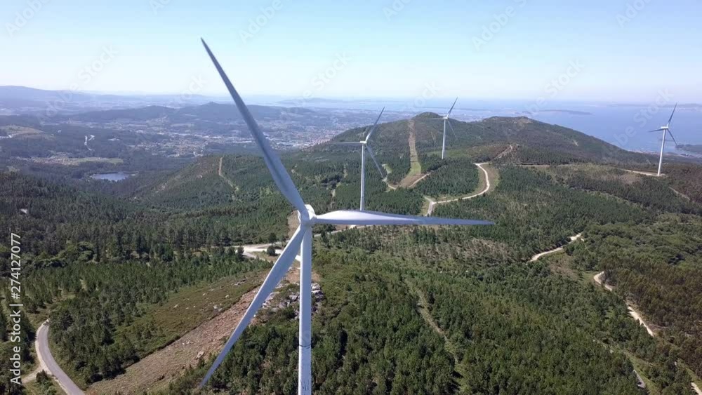 Drone flying backwords on windmill turbines, Aerial of eco-friendly energy production. Renewable energy future concept. Beautiful background shot of spinning blades Drone flying backwords on windmill turbines, Aerial of eco-friendly energy production. Renewable energy future concept. Beautiful background shot of spinning blades