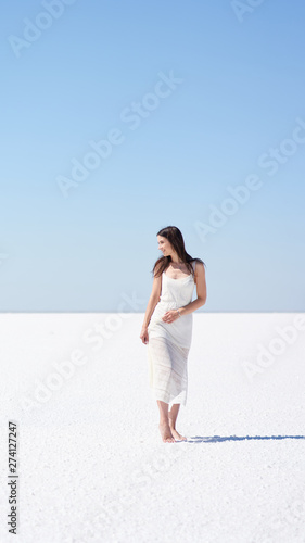 Happy girl in a white dress, salt lake Elton in the Volgograd region in Russia. photo