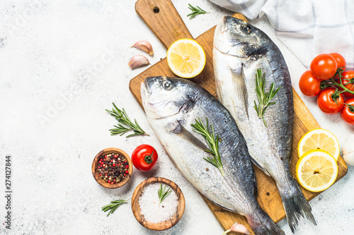 Photography Raw dorado fish on cutting board on the table.
