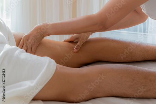 Asian man laying on bed for herb compress and pampering thai massage therapist  relaxation and wellness lifestyle.