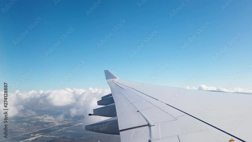 Wing of an airplane flying above the clouds Wing of an airplane flying above the clouds