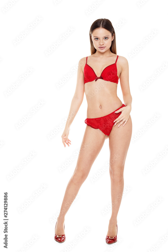 Young woman in red lingerie full length standing on white