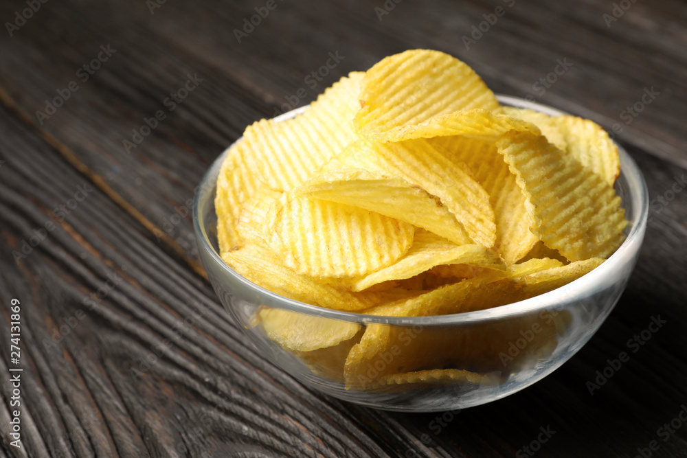 Bowl of potato chips on wooden table, closeup. Space for text Bowl of potato chips on wooden table, closeup. Space for text