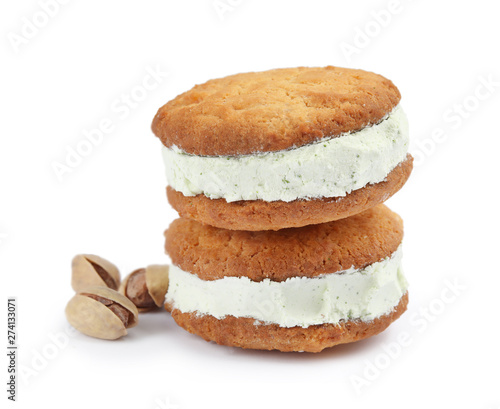 Sweet delicious ice cream cookie sandwiches and pistachios on white background