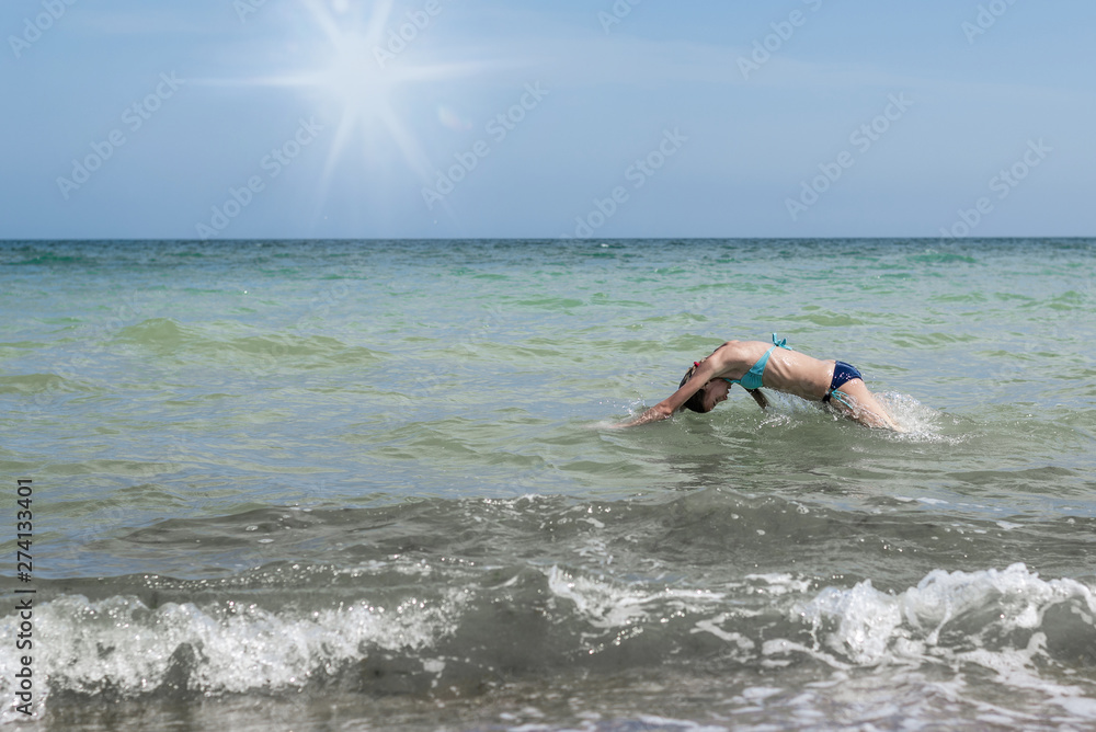 Girl jumping into the sea.