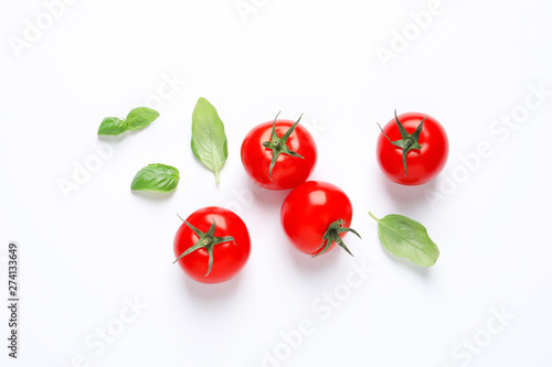 Composition with ripe cherry tomatoes and basil leaves on white background, top view