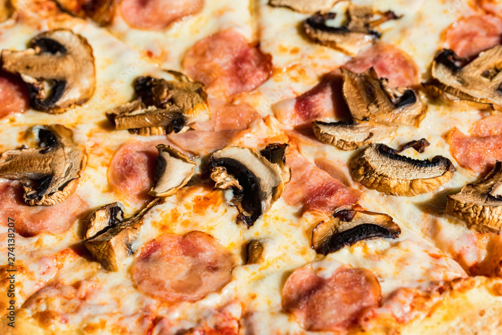 Delicious fresh pizza with salami, mushrooms and cheese close up texture Delicious fresh pizza with salami, mushrooms and cheese close up texture