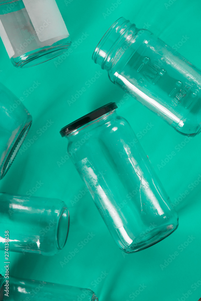 Glass jars with lids, teal green background, top view flat lay recycling concept Glass jars with lids, teal green background, top view flat lay recycling concept