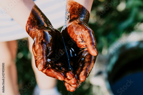 man, hand pour oil into it. have toning. close-up. photo