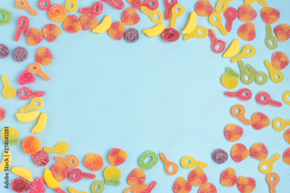 Blue paper background with sugary jellies and blank notepad. Place for your text. Cozy sweet background