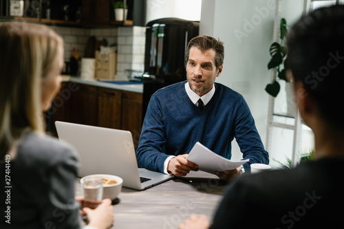 Real estate agent having a meeting with a couple at their home.