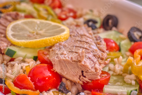 Detail of rice salad with fresh vegetables and grilled mackerel