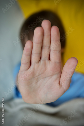 Teenage boy saying no with palm of hand