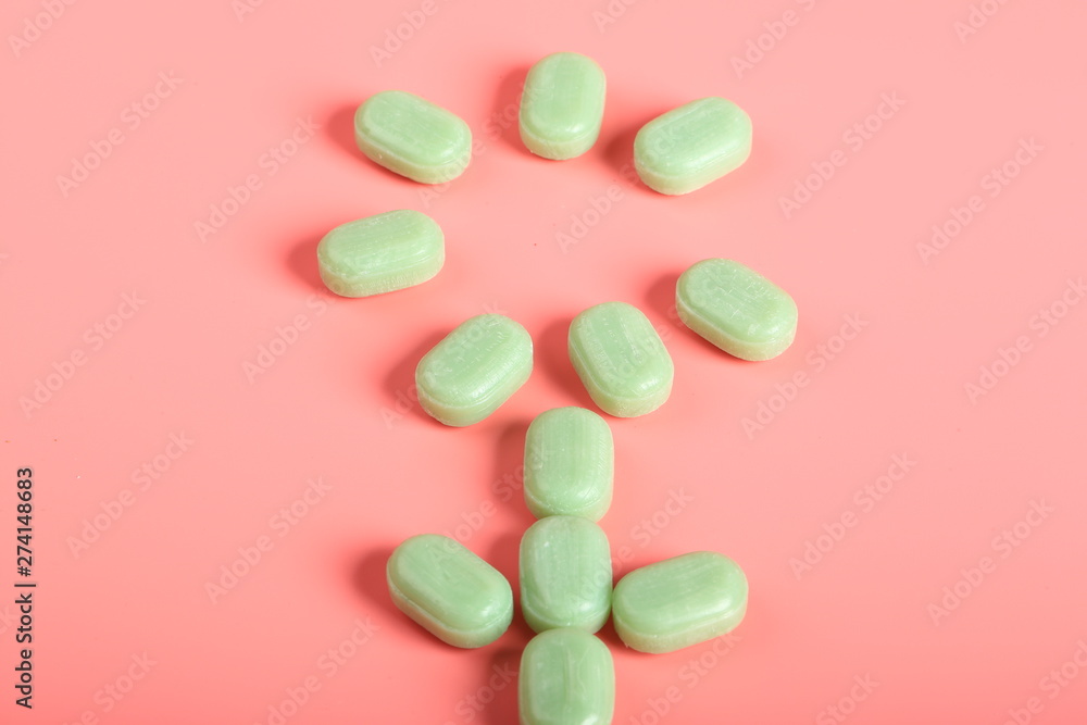 mint candy on a pink background. candy from a sore throat and cough mint candy on a pink background. candy from a sore throat and cough