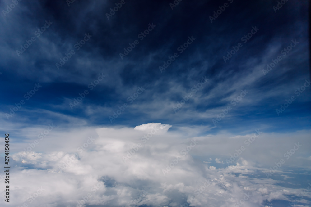 Fototapeta premium Plane window view with blue sky and beautiful clouds. As seen through window of an aircraft. View of wing & ocean. Airplane from city Bangkok to island Bali.