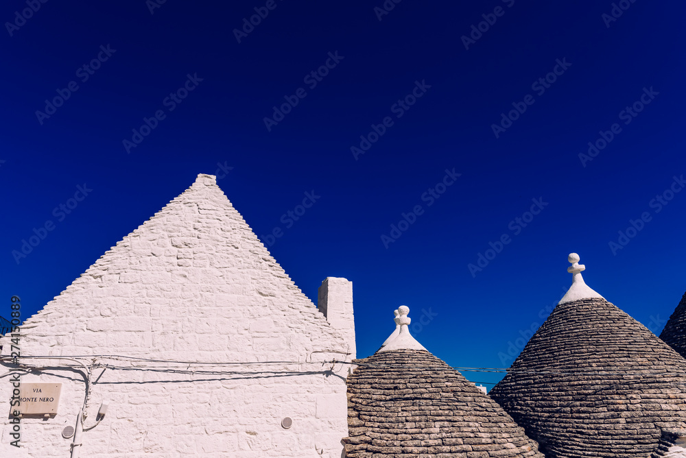 Houses of the tourist and famous Italian city of Alberobello, with its typical white walls and trulli conical roofs. Houses of the tourist and famous Italian city of Alberobello, with its typical white walls and trulli conical roofs.