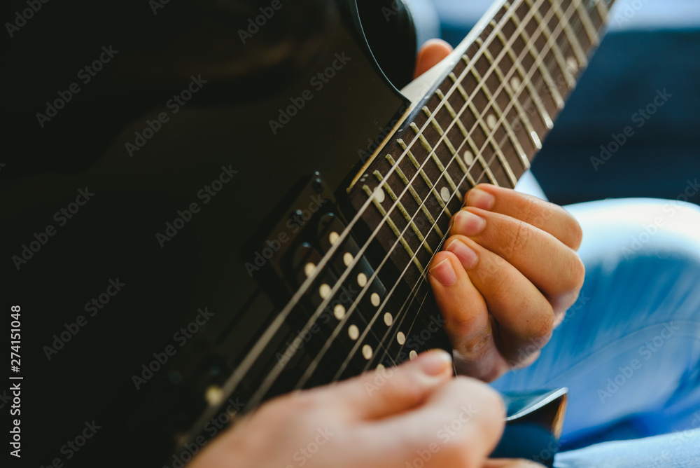 Placing the fingers on a guitar to play some notes by a professional guitarist.