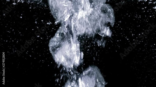Vigorously bubbling water. Boiling effect. Air particles moving fast on black background. photo